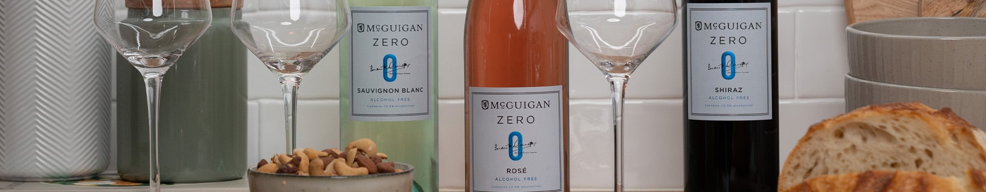 McGuigan Zero wine bottles with glasses and snacks